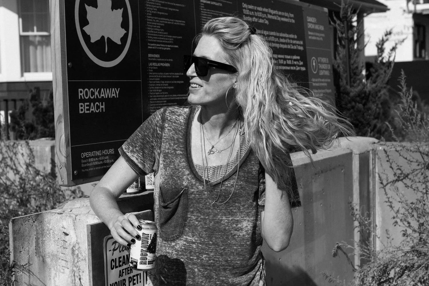 Founder Bridget Standing at Rockaway Beach Sign